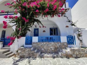 a blue and white building with pink flowers on it at Family house by the seaside of Karavostasis in Karavostasi