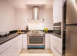 a kitchen with white cabinets and a stove at Miskawaan Villa Sila in Mae Nam