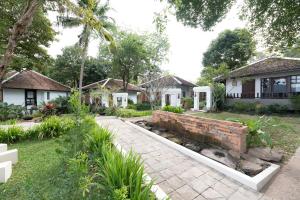 una casa con un muro di mattoni nel cortile di Tohsang Heritage Khongjiam a Khong Chiam