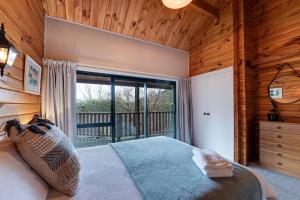 a bedroom with a bed and a large window at Alpine Hide Away - 2 bedroom in Closeburn