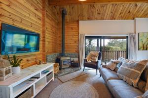 a living room with a couch and a large tv at Alpine Hide Away - 2 bedroom in Closeburn