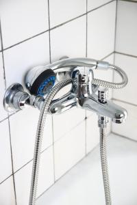 un soffione doccia con tubo in bagno di Virserum Hostel a Virserum