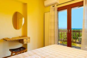 a bedroom with a bed and a mirror and a window at Istron Agnanti in Agios Nikolaos