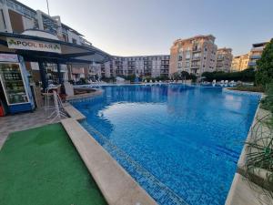 a large swimming pool with blue water in a building at Studio Apartment with balcony 300m from beach in Sunny Beach