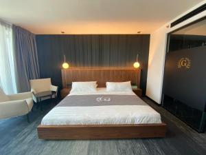 1 dormitorio con 1 cama grande y 1 silla en Golan Hotel en Tiberias