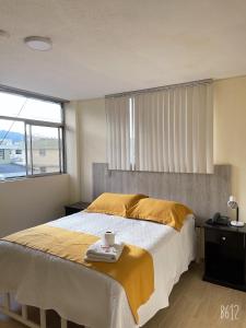 1 dormitorio con 1 cama grande con manta amarilla en Terraza Dreams, en Quito