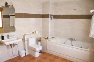 a bathroom with a toilet and a sink and a bath tub at Casa Rural Magnanimvs in Vilafamés +25 photos