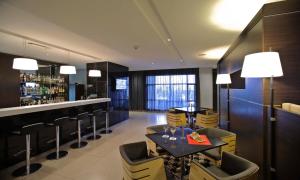 a restaurant with a bar and a table and chairs at Eka Hotel Nairobi in Nairobi