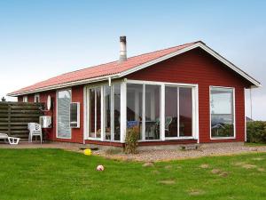 a red house with large sliding glass doors at Three-Bedroom Holiday home in Lemvig 1 in Lemvig