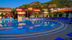 een zwembad op een resort met stoelen en parasols bij Ölüdeniz Turquoise Hotel - All Inclusive in Oludeniz