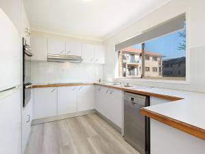 una cucina con mobili bianchi e una finestra di San Chelsea 16 a Gold Coast Altre 4 foto