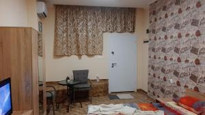 ein Wohnzimmer mit einem Tisch und einem TV in der Unterkunft Арт in Sliven