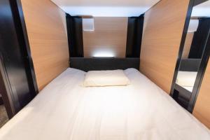 a bedroom with a white bed with a wooden headboard at SAMURAI STAY 黄金町-Male Only in Nishi-hiranumachō