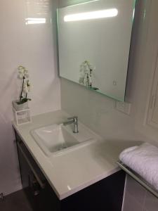 Baño blanco con lavabo y espejo en Chic 2 Bedroom Keilor, en St Albans
