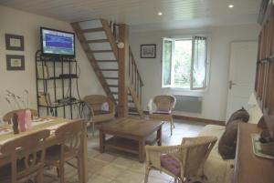 sala de estar con escalera, mesa y sillas en La Vigneronne, en Dijon