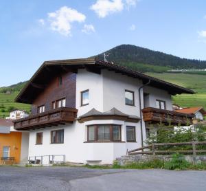 ein großes weißes Haus mit Holzbalkonen darauf in der Unterkunft Ferienhaus Peter Spöttl in Nauders