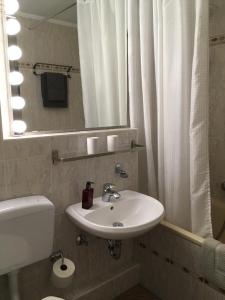 ein Badezimmer mit Waschbecken, Toilette und Spiegel in der Unterkunft Seaside in Glücksburg