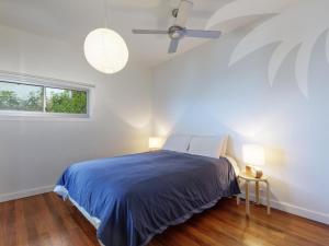 a bedroom with a bed and a ceiling fan at Sea Shack in Seal Rocks