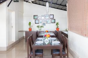 a dining room with a long table and chairs at Sanctum Suites Domlur Bangalore in Bangalore