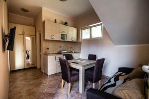 una cucina e una sala da pranzo con tavolo e sedie di Petrovic apartmani a Tivat