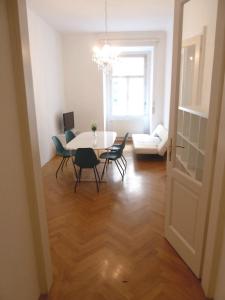 uma sala de jantar com uma mesa e cadeiras num quarto em Sobieski Stefansdom Apartments em Viena