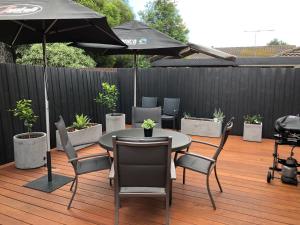 a patio with a table and chairs and an umbrella at Chic 2 Bedroom Keilor in St Albans