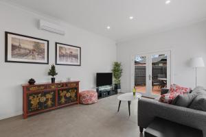 a living room with a couch and a tv at Chic 2 Bedroom Keilor in St Albans