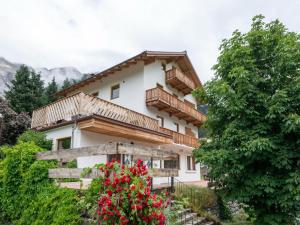 a house in the mountains with flowers at Holiday home near St Anton am Arlberg with sauna in Sankt Anton am Arlberg