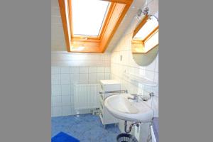 a bathroom with a sink and two skylights at Ferienwohnungen Maurer Höhenberg in Aschau im Chiemgau +35 photos