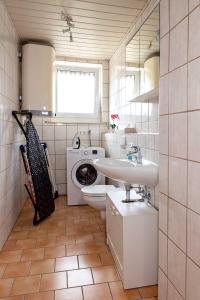 a bathroom with a washing machine and a sink at Monteurunterkunft Windischeschenbach by HausGruenerBaum in Windischeschenbach +24 photos