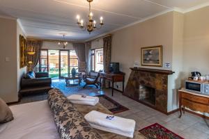 a living room with a couch and a fireplace at Antiqua Guest House in George