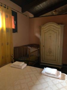 a bedroom with a crib with two towels on a bed at Chorisia Relais in Roccapiemonte