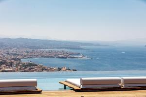 two beds sitting on top of a table with the ocean at Cavo Dago in Chania Town