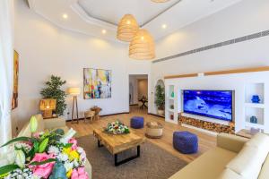 ein Wohnzimmer mit einem großen Flachbild-TV in der Unterkunft The S Holiday Homes - Stunning 5 Bedrooms Villa at the Palm Jumeirah with Private Beach and Pool in Dubai