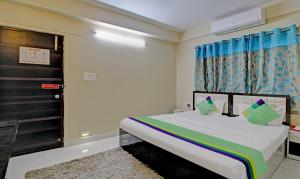 1 dormitorio con cama, ventana y puerta en FabHotel Ashraya Inn, en Calcuta