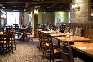 a dining room with wooden tables and chairs at Hadley Bowling Green Inn in Droitwich