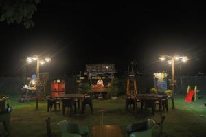 um parque infantil à noite com mesas e luzes em Corbett Treat Resort em Ramnagar