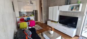 uma sala de estar com uma televisão de ecrã plano e um sofá em Apartment Przno LUX em Podličak