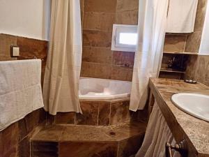 ein Badezimmer mit einer Dusche, einer Badewanne und einem Waschbecken in der Unterkunft Pantheon in Serres