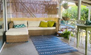 a porch with a wicker couch and a table at Rex Hotel - Bebeka's in Zakharo