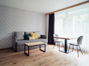 ein Wohnzimmer mit einem Sofa und einem Tisch in der Unterkunft Hotel Neu-Schönstatt in Quarten