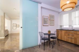 a kitchen with a table and chairs in a room at Genteel Home Litoral in Málaga