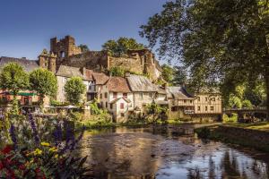 un village avec une rivière et un château dans l'établissement Villa au bord de la Rivière avec Jacuzzi, à Ségur-le-Château