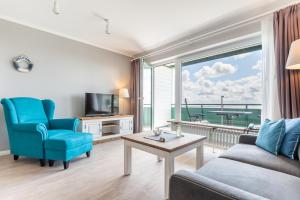 a living room with a couch and a table and a window at Seegarten Appartements Büsum in Büsum