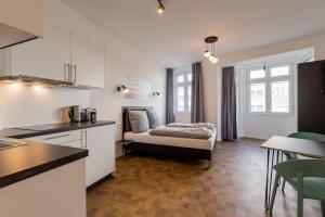 a kitchen with a bed in the middle of a room at Nena Apartments Hermannplatz in Berlin