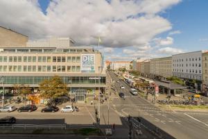 a busy city street with cars parked in front of buildings at Nena Apartments Hermannplatz in Berlin