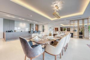 een eetkamer met een lange tafel en stoelen bij Palm Jumeirah Luxury Apartments by Propr in Dubai