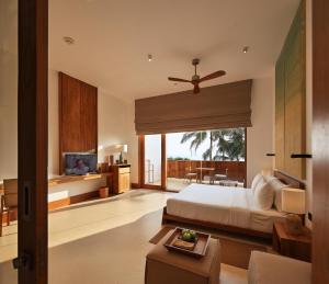 a bedroom with a bed and a living room at Riff Hikkaduwa in Hikkaduwa