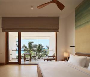 a bedroom with a bed and a view of the ocean at Riff Hikkaduwa in Hikkaduwa