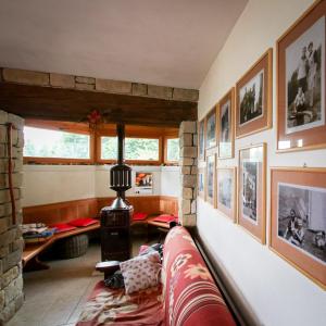 een woonkamer met een bank en schilderijen aan de muur bij Baita Agaz in Sovramonte